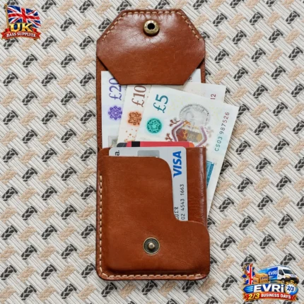 Handmade brown leather snap wallet with brass snap button on patterned fabric