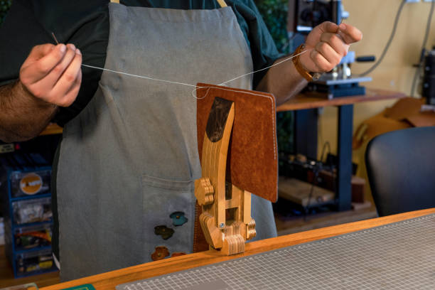 Artisan hand stitching leather with the traditional saddle stitch technique